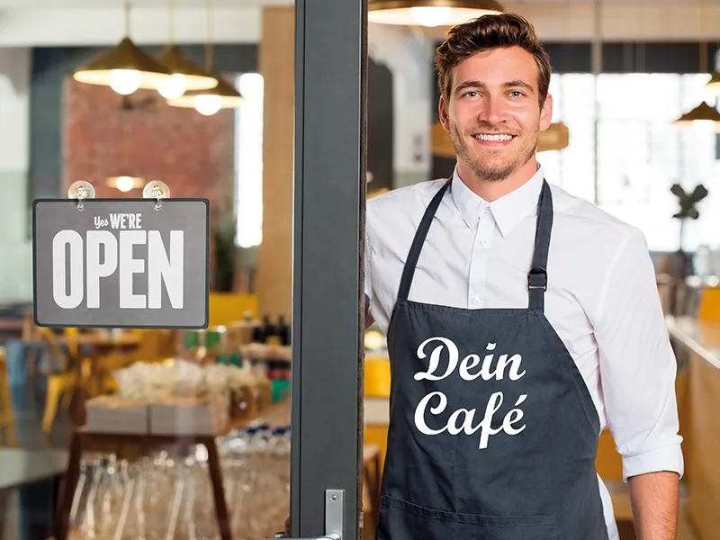 Ein Caféinhaber mit einer personalisierten Schürze.