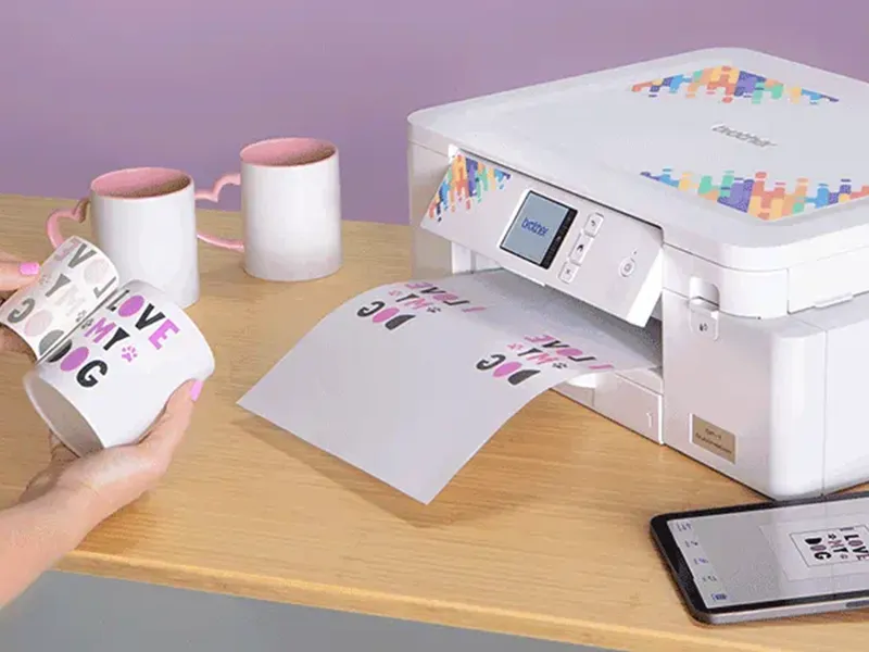 Die vom Brother ausgedruckten Motive werden auf eine Tasse sublimiert.
